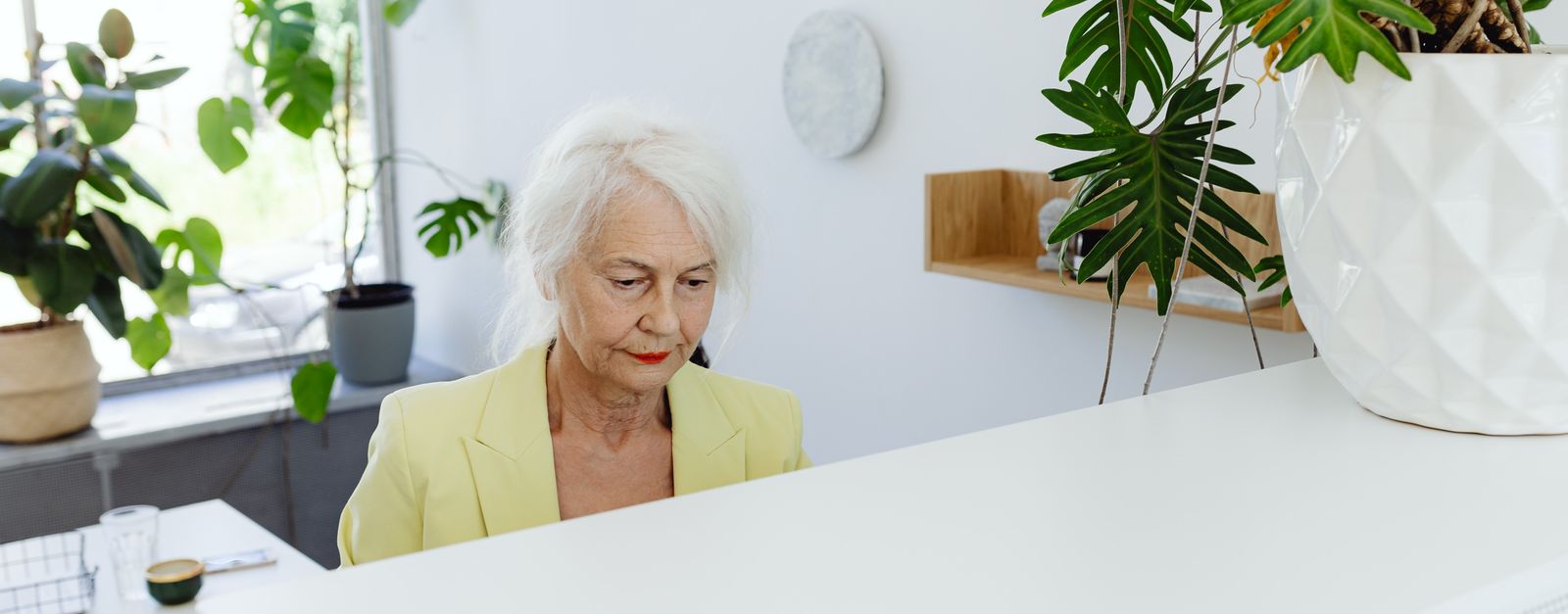 An older New Mexico worker at a small-business front desk, illustrating how Medicare coordinates with employer coverage for people working past age 65
