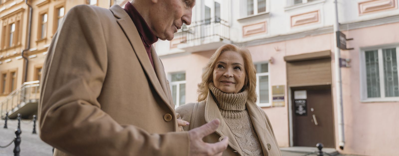 An older couple talking as they walk along a sunlit street — Santa Fe retirees weighing their 2027 Medicare options after the Presbyterian Medicare Advantage discontinuation